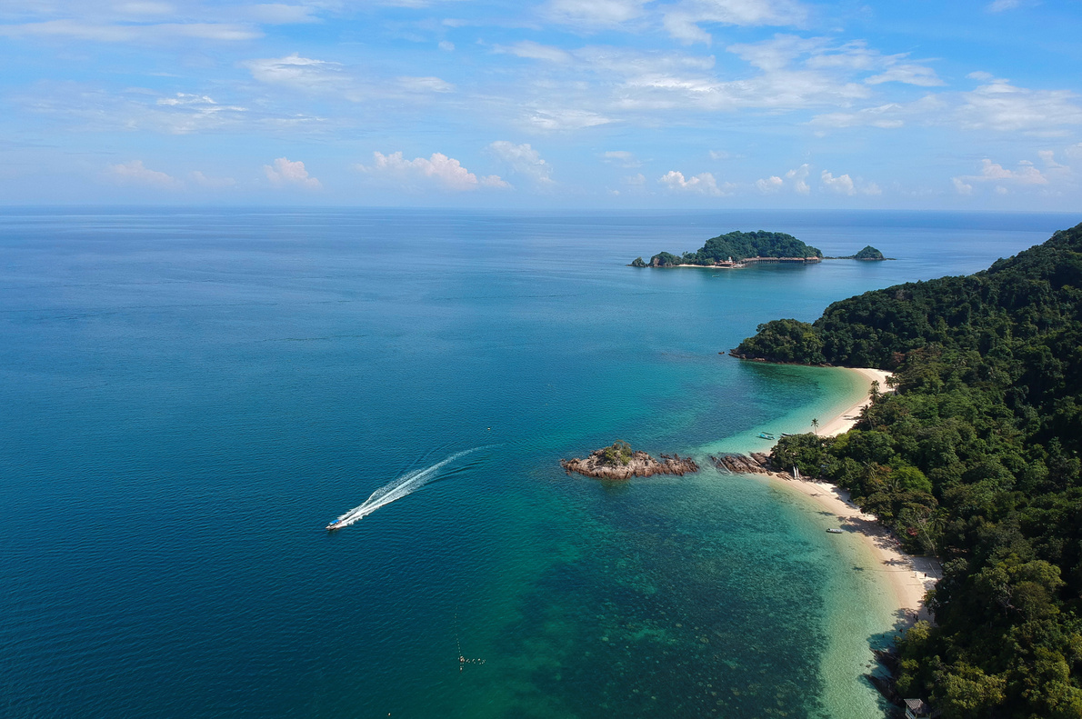 Aerial View of White Boat Traveling Near Green Island